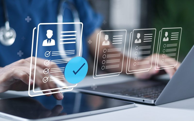 Laptop with digital icons representing medical records, a heart symbol, and an insurance checkmark, symbolizing automated standardization and normalization of provider data.